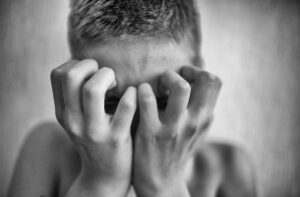 photo of a boy covering his face iwth his hands for a blog post about sexual abuse of boys